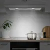 A kitchen counter with a stainless steel pot on a stovetop, a potted plant, and kitchen utensils. Voir les images du produit