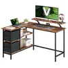 An L-shaped desk with a laptop, monitor, keyboard, clock, and headphones. Náhled obrázku produktu