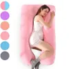 A pregnant woman is sleeping on a large U-shaped pink pregnancy pillow. Produktbild-Vorschau