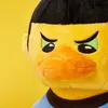 A close-up of a plush toy duck with a grumpy expression. Voir les images du produit