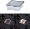 A collage showing a solar-powered LED ground light. The top image is a product shot on a white background, and the bottom two images show the light installed in paving stones at night, both unlit and lit. Produktbild-Vorschau
