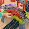 A child's hand is operating a toy train track mechanism, with two toy trains on the tracks. Náhľad obrázku produktu
