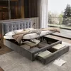 A modern bedroom with a large storage bed, open to reveal storage compartments. Large windows show a garden view. Produktbild-Vorschau