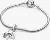 A silver Pandora bracelet with two charms, a baby shoe and a heart with footprints, is displayed against a white background. Anteprima dell’immagine prodotto