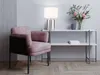 A pink armchair sits next to a console table with a lamp and flowers. Produktbild-Vorschau