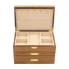 An open wooden jewelry box with multiple compartments and drawers. Voir les images du produit