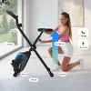 A woman is demonstrating the adjustable seat height of a foldable exercise bike indoors. Anteprima dell’immagine prodotto