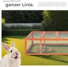 A rabbit enclosure in a garden setting with a rabbit in the foreground. Produktbild-Vorschau