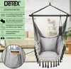 A hanging chair with a side pocket and a pillow, displayed indoors with a blurred background of a living room. Produktbild-Vorschau