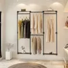 A minimalist clothing rack with multiple shelves and hanging rods, displaying various garments in a clean, well-lit room. Produktbild-Vorschau