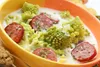 A close-up of a bowl of soup with Romanesco broccoli and sliced sausage. Voir les images du produit