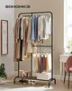 A clothing rack filled with clothes and shoes in a room. Náhled obrázku produktu