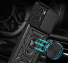 A black phone case with a camera cover and a ring holder is shown attached to a car vent mount. Podgląd zdjęcia produktu