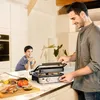 A father and son are in a kitchen, preparing food with a grill. Podgląd zdjęcia produktu