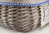 Close-up of a woven basket with a blue and white checkered trim and a lace-edged fabric label. Produktbild-Vorschau