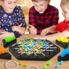 Three children are playing a board game at a table. Produktbild-Vorschau