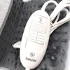 A close-up of a Beurer heating pad controller and part of the pad. Produktbild-Vorschau