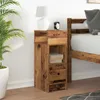 A bedside table next to a bed, with a lamp and an alarm clock on top. Náhled obrázku produktu