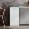 A white freestanding dishwasher is shown in a modern kitchen setting, next to a wooden chair and a countertop. Produktbild-Vorschau