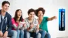 Four young people are sitting on a couch, laughing and playing video games. A battery is shown to the right of the group. Produktbild-Vorschau