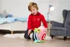 A young boy is playing with a plush toy snail in a bedroom. Voir les images du produit