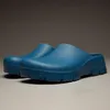A pair of blue clogs on a neutral background. Produktbild-Vorschau