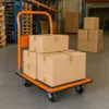 A warehouse scene with a hand truck loaded with cardboard boxes. Podgląd zdjęcia produktu