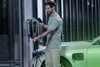 A man is charging an electric car with a wallbox charger. Produktbild-Vorschau