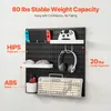 A black pegboard wall organizer with various items attached, including a game console, controllers, headphones, mice, a keyboard, and a small container. Produktbild-Vorschau