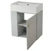 A light gray vanity cabinet with a white sink on top. One of the cabinet doors is open, revealing two shelves inside. The door has a fluted design and a small gold knob. Podgląd zdjęcia produktu