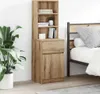 A tall, narrow wooden cabinet with shelves and a drawer, placed next to a bed in a bedroom. Náhled obrázku produktu