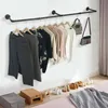 A wall-mounted clothing rack with various garments and accessories displayed. Produktbild-Vorschau