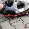 A gloved hand is shown installing snow chains on a car tire. Produktbild-Vorschau