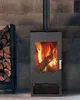 A modern wood-burning stove with a fire burning inside, placed against a stone-tiled wall. A stack of firewood is visible to the left. Produktbild-Vorschau