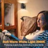A woman is reading a book in a dimly lit room, illuminated by a wall-mounted LED light. Produktbild-Vorschau