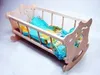 A wooden rocking cradle for a doll, with bedding inside. Náhľad obrázku produktu