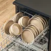 A dishwasher rack filled with beige ceramic plates and bowls. Náhled obrázku produktu