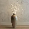 A tall, decorative vase filled with illuminated branches. Produktbild-Vorschau