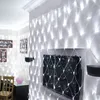 A living room decorated with a net of white fairy lights draped over a wall and a television. Náhled obrázku produktu