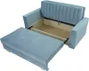 A blue sofa with its storage compartment open and a detached ottoman in front. Produktbild-Vorschau