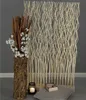 A decorative room divider made of natural branches, displayed with a vase of cotton and dried branches, a candle, and a book on a cushion. Náhľad obrázku produktu
