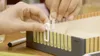 Hands interacting with a game or educational toy with numbered slots. Produktbild-Vorschau