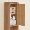 A close-up view of a narrow wooden cabinet with its door ajar, revealing shelves with storage boxes and soap dispensers. Náhled obrázku produktu
