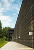 A modern wooden building with outdoor lighting and a walkway. Anteprima dell’immagine prodotto