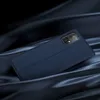 A dark blue flip case for a smartphone is displayed on a dark blue, satin-like fabric. Produktbild-Vorschau