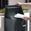 SoBuy Paketbox OGS65-DG in Dark Gray: Briefkasten-Funktion mit geöffneter Tür und eingeworfener Post vor Hauswand Vista previa de la imagen del producto
