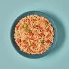 A bowl of rice with tomatoes and olives on a light blue background. Voir les images du produit