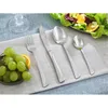 A table setting with cutlery, grapes, and a salad. Voir les images du produit