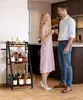 A couple is toasting with wine in front of a bar cart filled with bottles. Produktbild-Vorschau