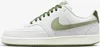 A side view of a white Nike Court Vision Low sneaker with green accents. Produktbild-Vorschau